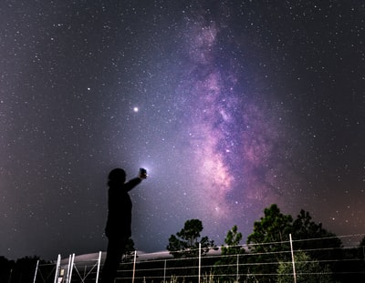 星夜下站在篱笆上的男人的剪影